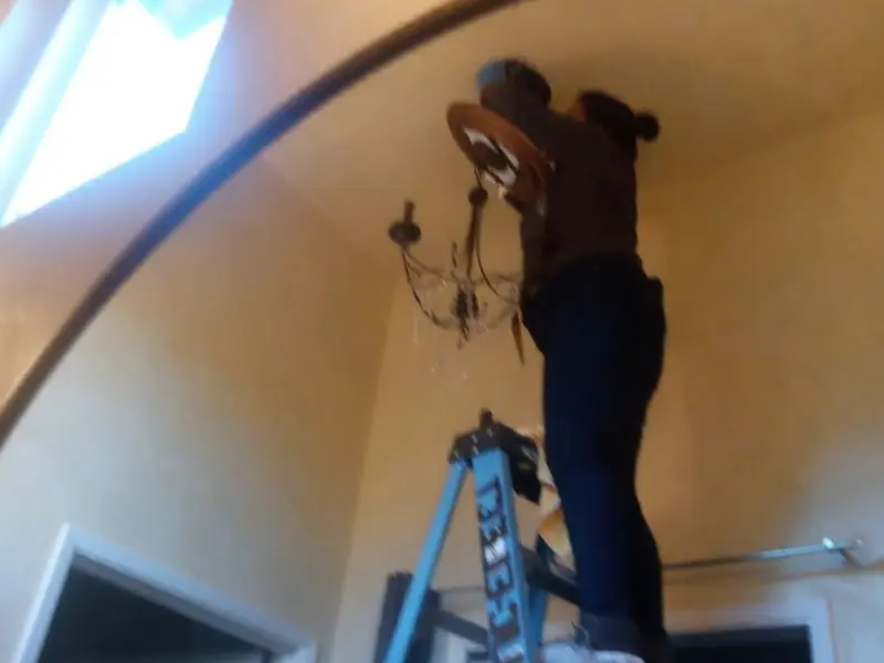 Electrician installing a chandelier in a Jefferson City residence